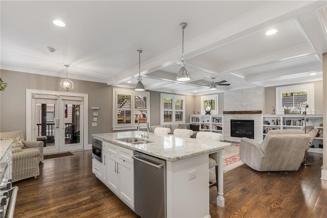 kitchen featuring recessed lighting, a breakfast bar, stainless steel dishwasher, a sink, and open floor plan