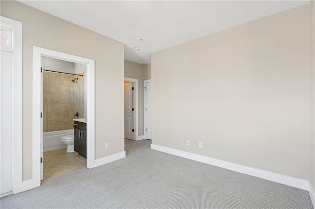 1199 Huff Rd NW Unit 112, Atlanta, GA 30318 - unfurnished bedroom featuring light carpet, light tile patterned flooring, and ensuite bath