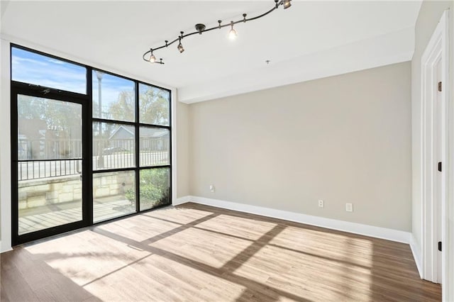 1199 Huff Rd NW Unit 112, Atlanta, GA 30318 - spare room with floor to ceiling windows, wood finished floors, and track lighting