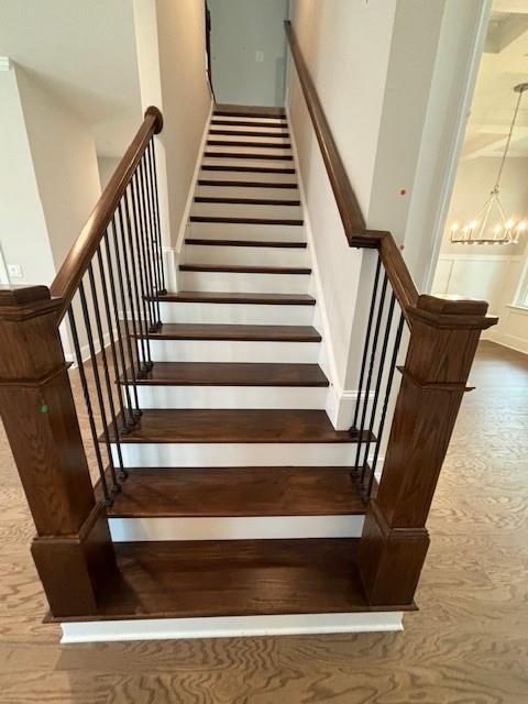 stairway featuring an inviting chandelier