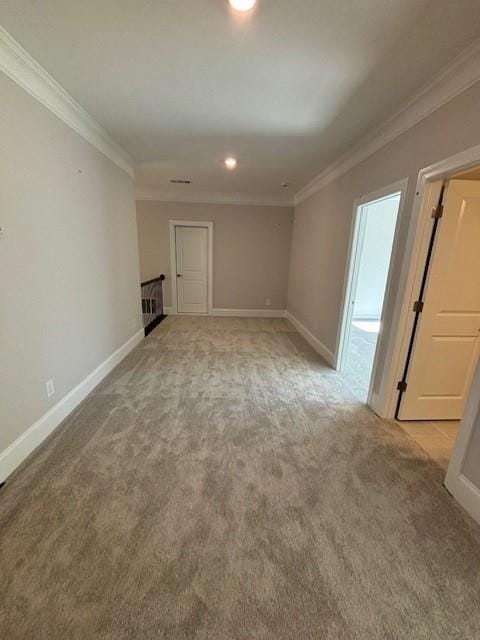 spare room featuring ornamental molding and light carpet