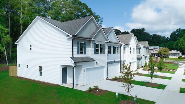 exterior space with a garage, a yard, board and batten siding, and concrete driveway