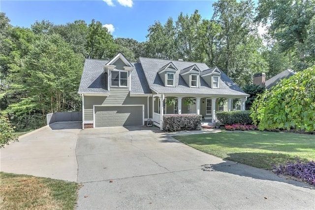 new england style home with a garage, a front lawn, and a porch