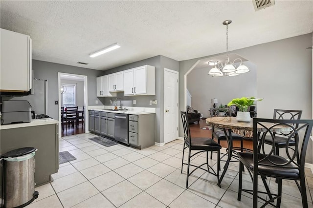 250 Kensington Trce, Stockbridge, GA 30281 - kitchen featuring stainless steel dishwasher, light countertops, a textured ceiling, a chandelier, and light tile patterned flooring