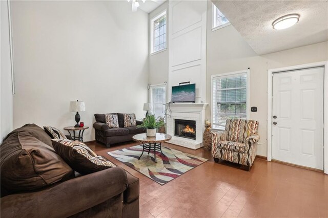 250 Kensington Trce, Stockbridge, GA 30281 - living area featuring a towering ceiling, healthy amount of natural light, a brick fireplace, and wood finished floors