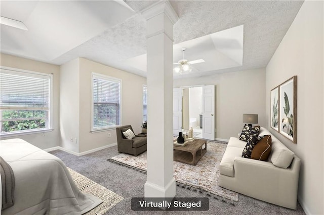 250 Kensington Trce, Stockbridge, GA 30281 - living area featuring carpet flooring, ceiling fan, ornate columns, baseboards, and a raised ceiling