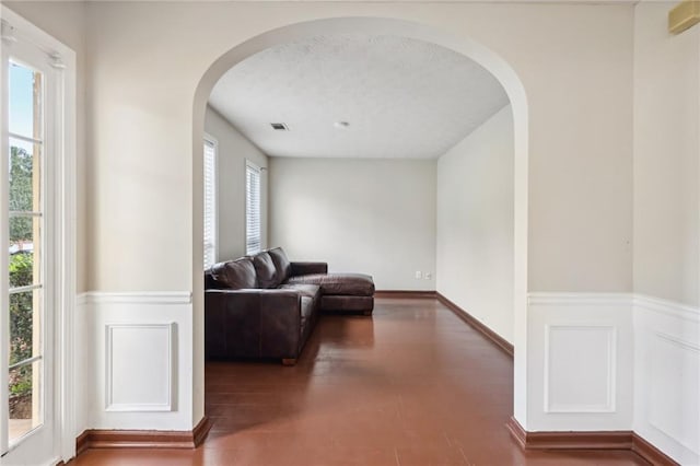 250 Kensington Trce, Stockbridge, GA 30281 - living room featuring wainscoting, arched walkways, wood finished floors, and a decorative wall