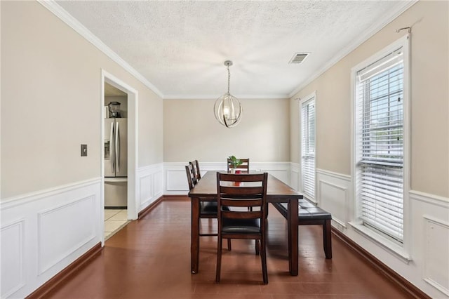 250 Kensington Trce, Stockbridge, GA 30281 - dining space featuring a textured ceiling, a chandelier, wainscoting, ornamental molding, and dark wood-style floors
