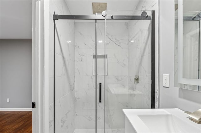 bathroom featuring wood-type flooring, walk in shower, and sink