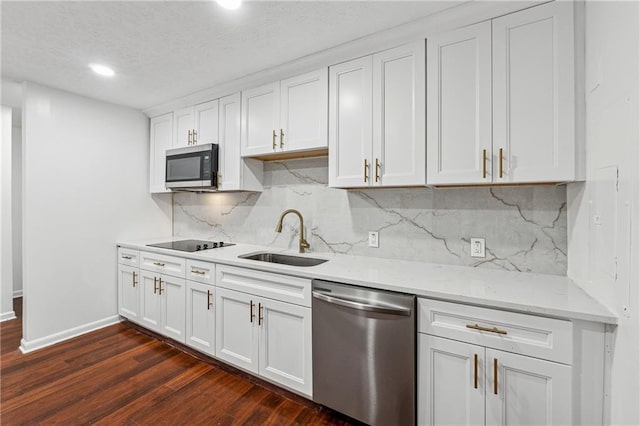 kitchen featuring appliances with stainless steel finishes, dark hardwood / wood-style flooring, tasteful backsplash, sink, and white cabinetry