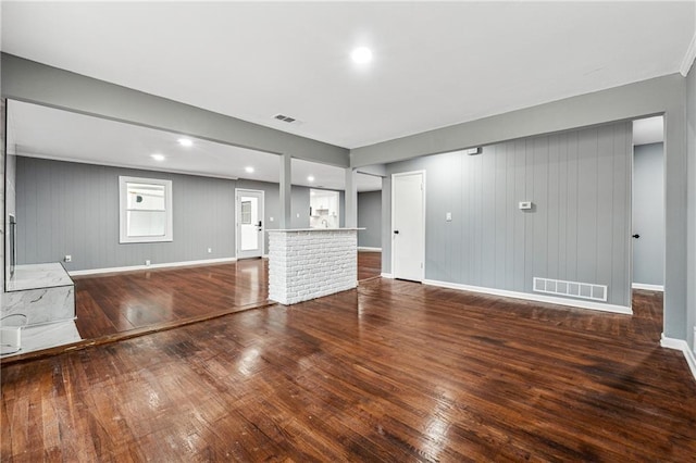 unfurnished living room featuring wooden walls and hardwood / wood-style flooring