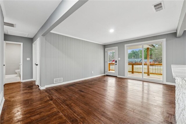 unfurnished living room with ornamental molding and dark wood-type flooring