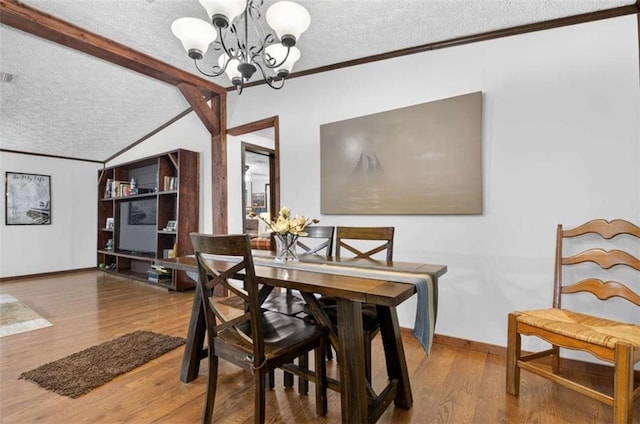 51 Ocoee Trl, Blue Ridge, GA 30513 - dining area with a textured ceiling, a chandelier, vaulted ceiling, ornamental molding, and wood finished floors