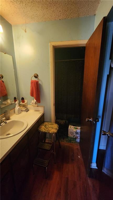 402 Emmett St, Riverdale, GA 30165 - bathroom featuring vanity, wood finished floors, and a textured ceiling