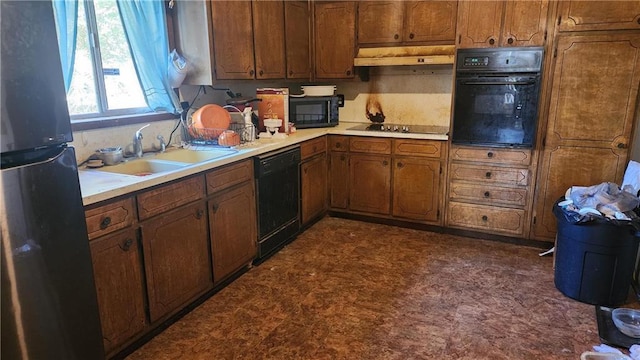 402 Emmett St, Riverdale, GA 30165 - kitchen with black appliances, light countertops, brown cabinetry, under cabinet range hood, and dark flooring