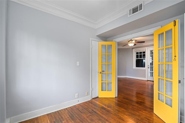 empty room featuring crown molding, visible vents, wood finished floors, baseboards, and french doors