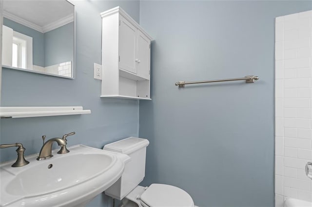 bathroom featuring crown molding, a sink, and toilet