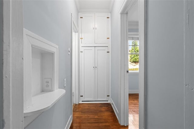 corridor featuring baseboards, dark wood finished floors, and ornamental molding