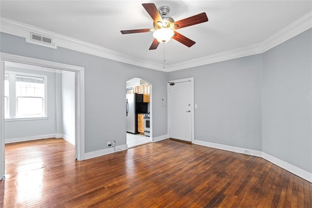 unfurnished room with visible vents, ornamental molding, ceiling fan, hardwood / wood-style flooring, and arched walkways