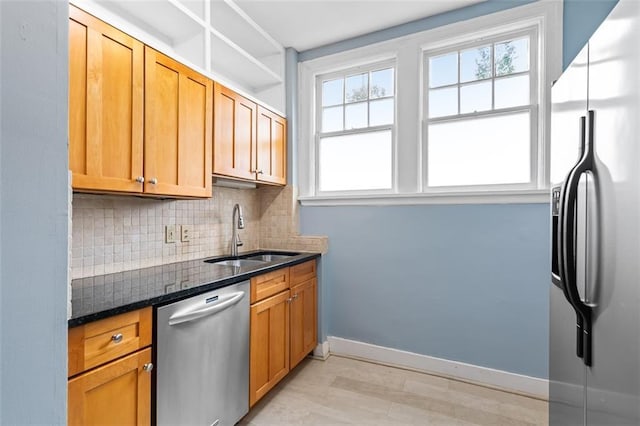 kitchen with decorative backsplash, stainless steel appliances, plenty of natural light, and a sink
