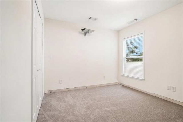carpeted spare room featuring baseboards
