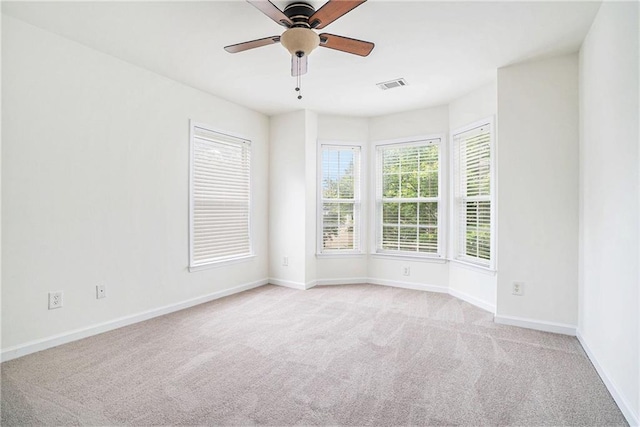 spare room with carpet floors, baseboards, and ceiling fan
