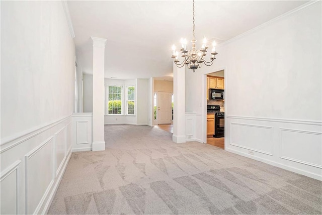 spare room with a decorative wall, light colored carpet, a chandelier, ornamental molding, and wainscoting