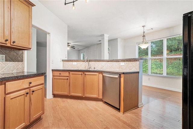 kitchen featuring stainless steel dishwasher, a sink, decorative backsplash, a peninsula, and light wood finished floors