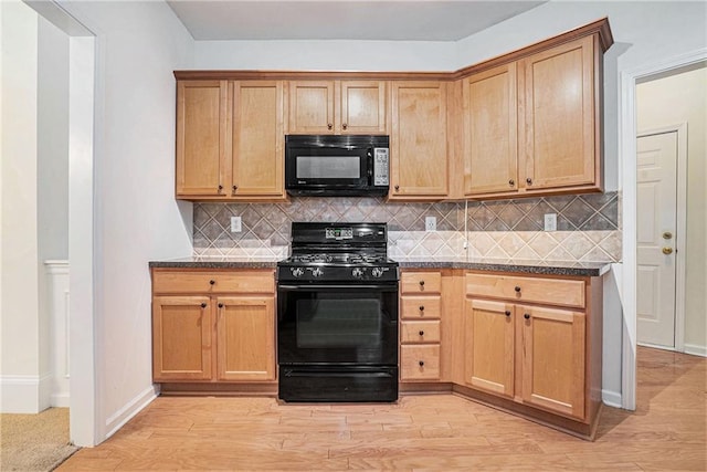 kitchen with black appliances, light wood-style flooring, and decorative backsplash