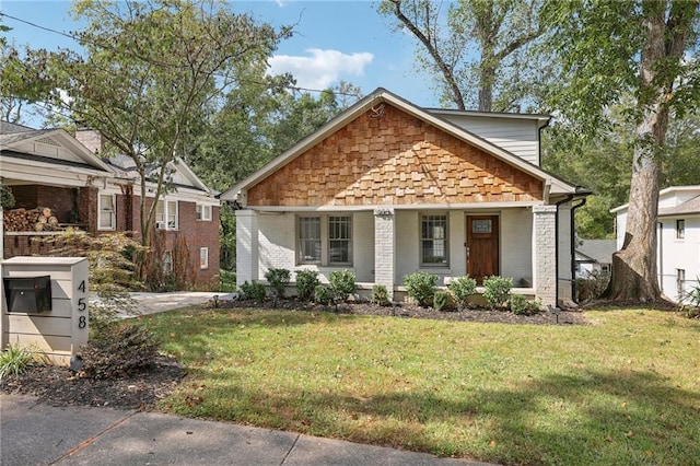 bungalow-style home featuring a front yard and covered porch