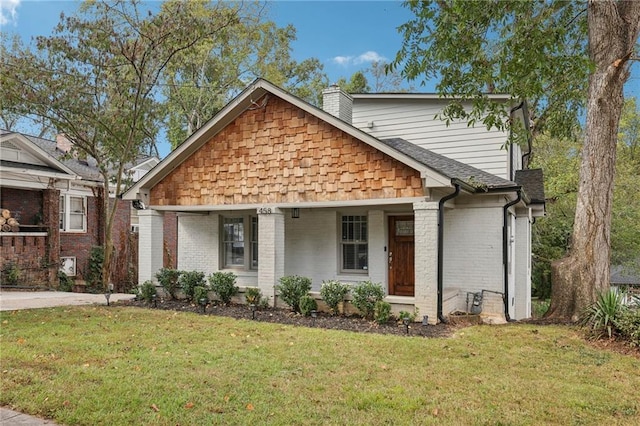 view of front of property featuring covered porch and a front lawn