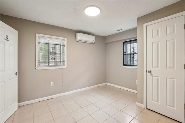 tiled spare room with a wall mounted air conditioner