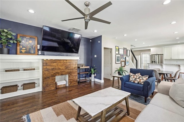 living room featuring ceiling fan, hardwood / wood-style floors, and built in shelves