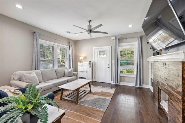 living room with ceiling fan, dark hardwood / wood-style flooring, and a fireplace