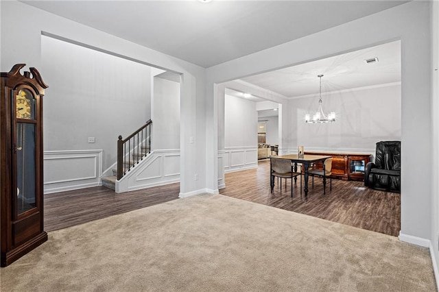 living room with carpet flooring, an inviting chandelier, and crown molding