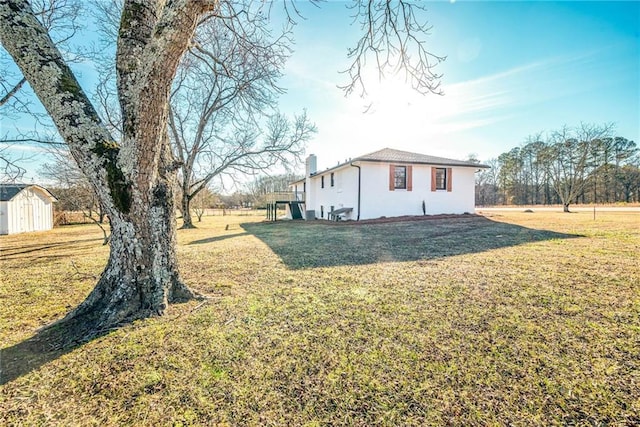 view of home's exterior featuring a storage shed and a yard