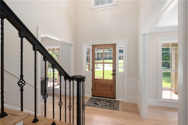 foyer featuring ornamental molding and light hardwood / wood-style flooring