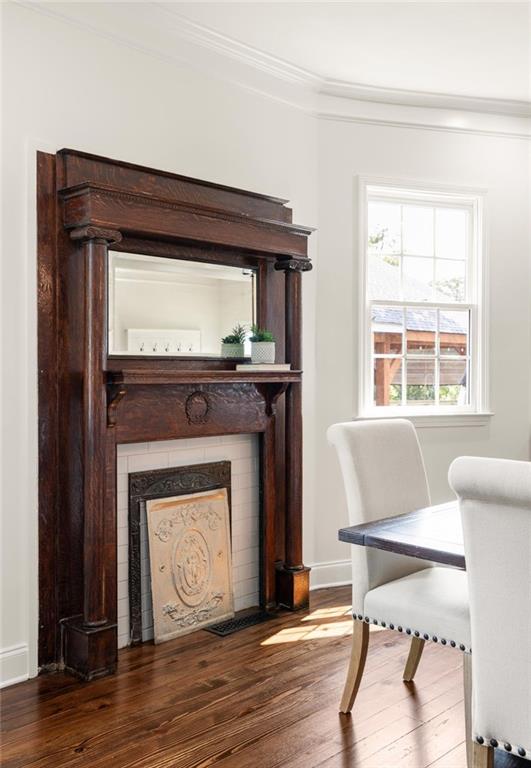178 Mayson Ave NE, Atlanta, GA 30307 - dining room with wood finished floors, a fireplace with flush hearth, crown molding, and baseboards
