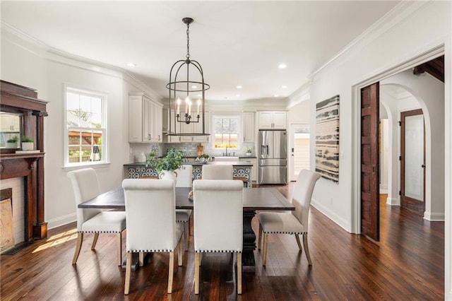 178 Mayson Ave NE, Atlanta, GA 30307 - dining space with arched walkways, dark wood-type flooring, ornamental molding, baseboards, and a chandelier