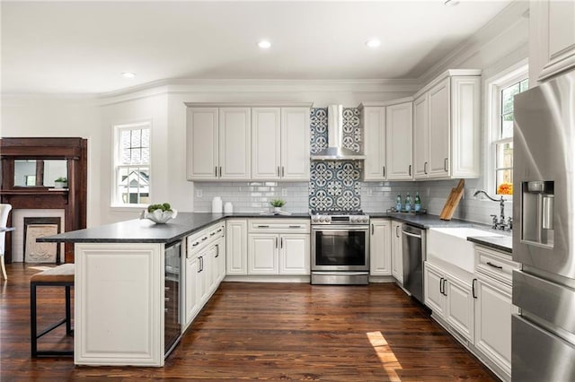 178 Mayson Ave NE, Atlanta, GA 30307 - kitchen featuring stainless steel appliances, wall chimney range hood, a peninsula, a sink, and ornamental molding