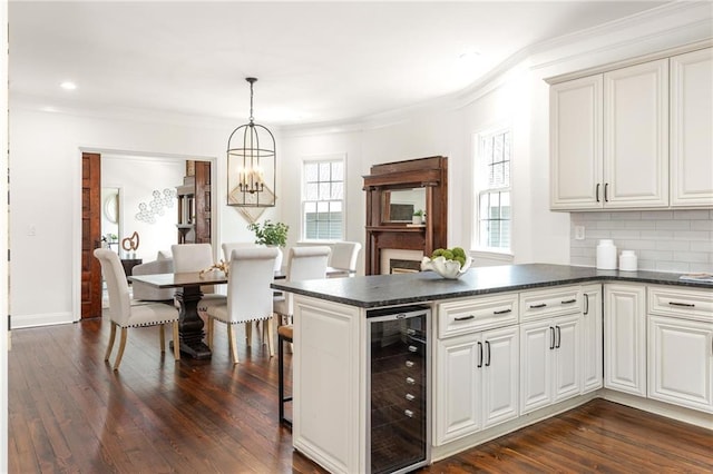178 Mayson Ave NE, Atlanta, GA 30307 - kitchen with beverage cooler, dark countertops, crown molding, a peninsula, and dark wood finished floors