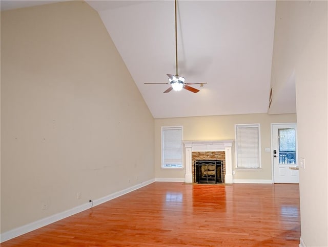 unfurnished living room featuring hardwood / wood-style flooring, ceiling fan, a fireplace, and high vaulted ceiling