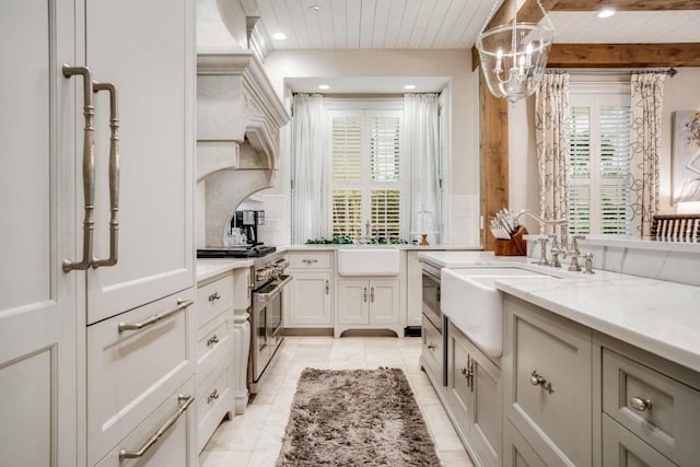 kitchen featuring pendant lighting, backsplash, light tile patterned floors, high end stainless steel range, and light stone countertops