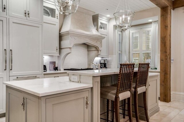 kitchen with a kitchen island, custom exhaust hood, and white cabinets