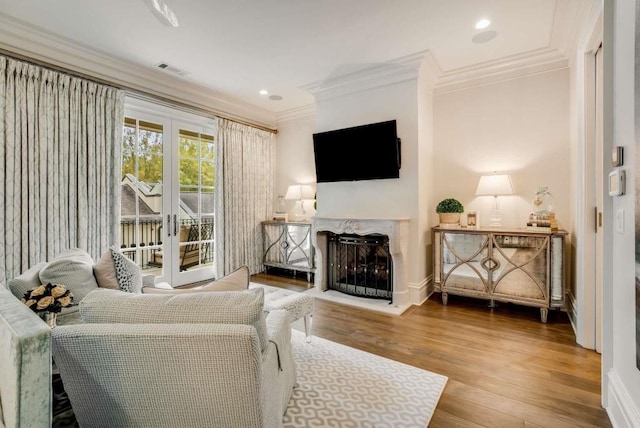 living room with hardwood / wood-style flooring, ornamental molding, and french doors