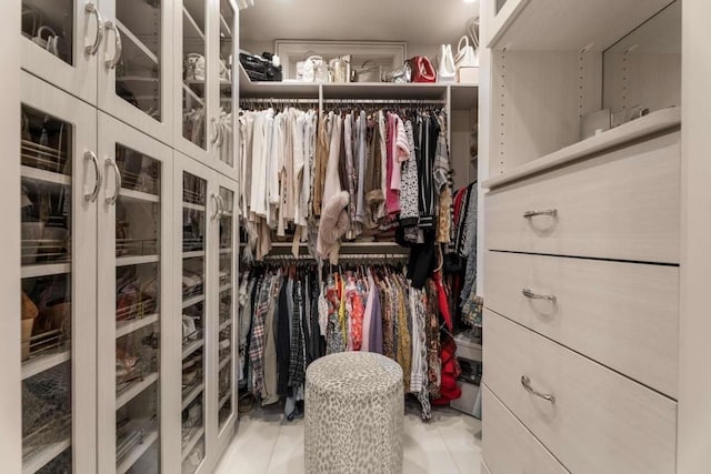 walk in closet with light tile patterned floors