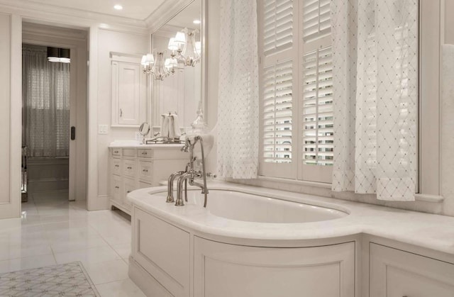 bathroom featuring an inviting chandelier, vanity, ornamental molding, a tub to relax in, and tile patterned floors