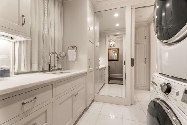 interior space featuring stacked washer / dryer, ornamental molding, sink, and light tile patterned floors