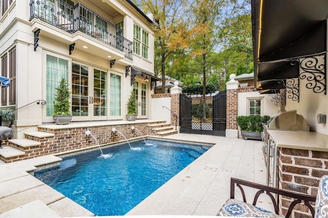 view of swimming pool with a patio and an outdoor kitchen