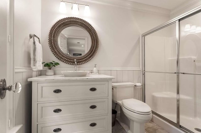 bathroom with an enclosed shower, vanity, ornamental molding, and toilet